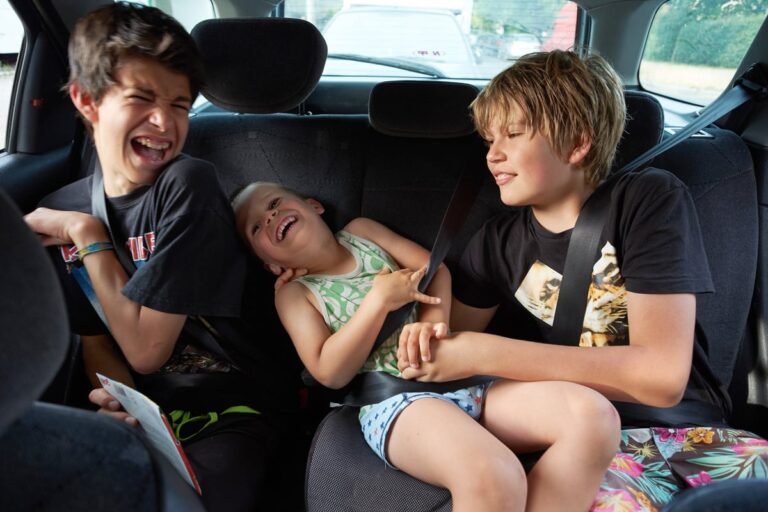 Three children in back seat of car PhNiqCM