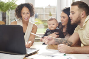 advisor reviewing data on a laptop with a family