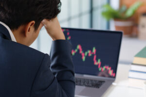 person staring at downward trending graph on a laptop