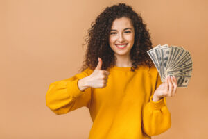 22 06 16 a person holding a fan of money and holding up a thumbs up sign gettyimages 1215140052