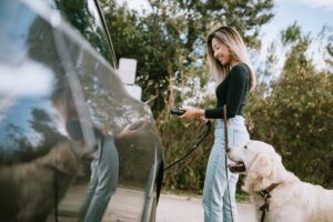 Woman with dog about to charge her electric car fYIpUAw