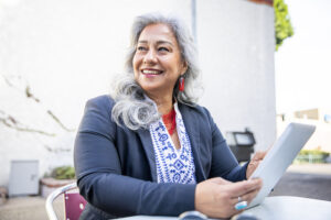 fashionable person smiles while holding tablet device