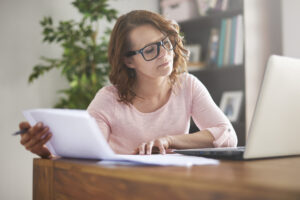 investor considers laptop with notebook