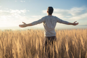 person standing out in a field enjoying nature