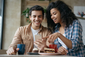 two people looking at a phone in a cafe