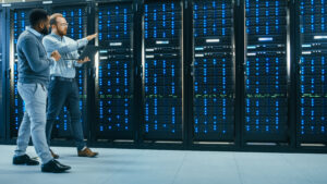 two software engineers walking down an aisle of a data center