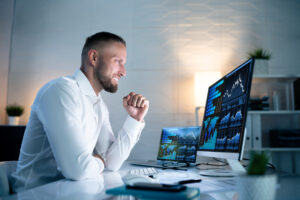 excited investor looks at financial charts on computer