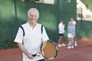 older man holding tennis racket gettyimages 136591899