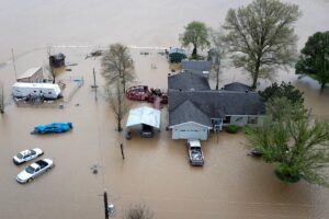 An aerial view shows floodwaters surrounding a rural home