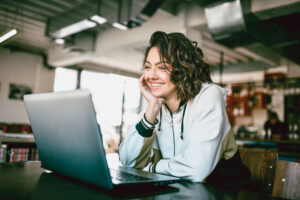 analyst smiling and studying on a laptop