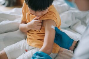 doctor applying bandage after vaccinating child