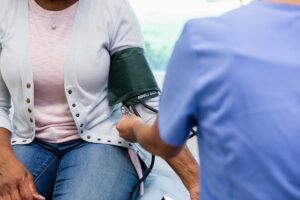 healthcare worker checks patients blood pressure