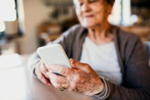 older person using smartphone at table