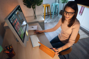 person buying a stock while using a computer and a tablet