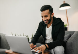 person smiling and looking at laptop