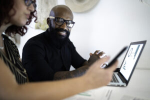 two investors work at a table with a laptop and a phone