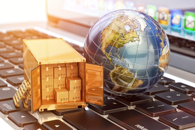 globe and shipping container resting on laptop keyboard