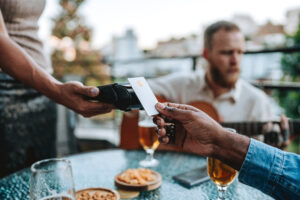 person paying for a restaurant meal with a payment card